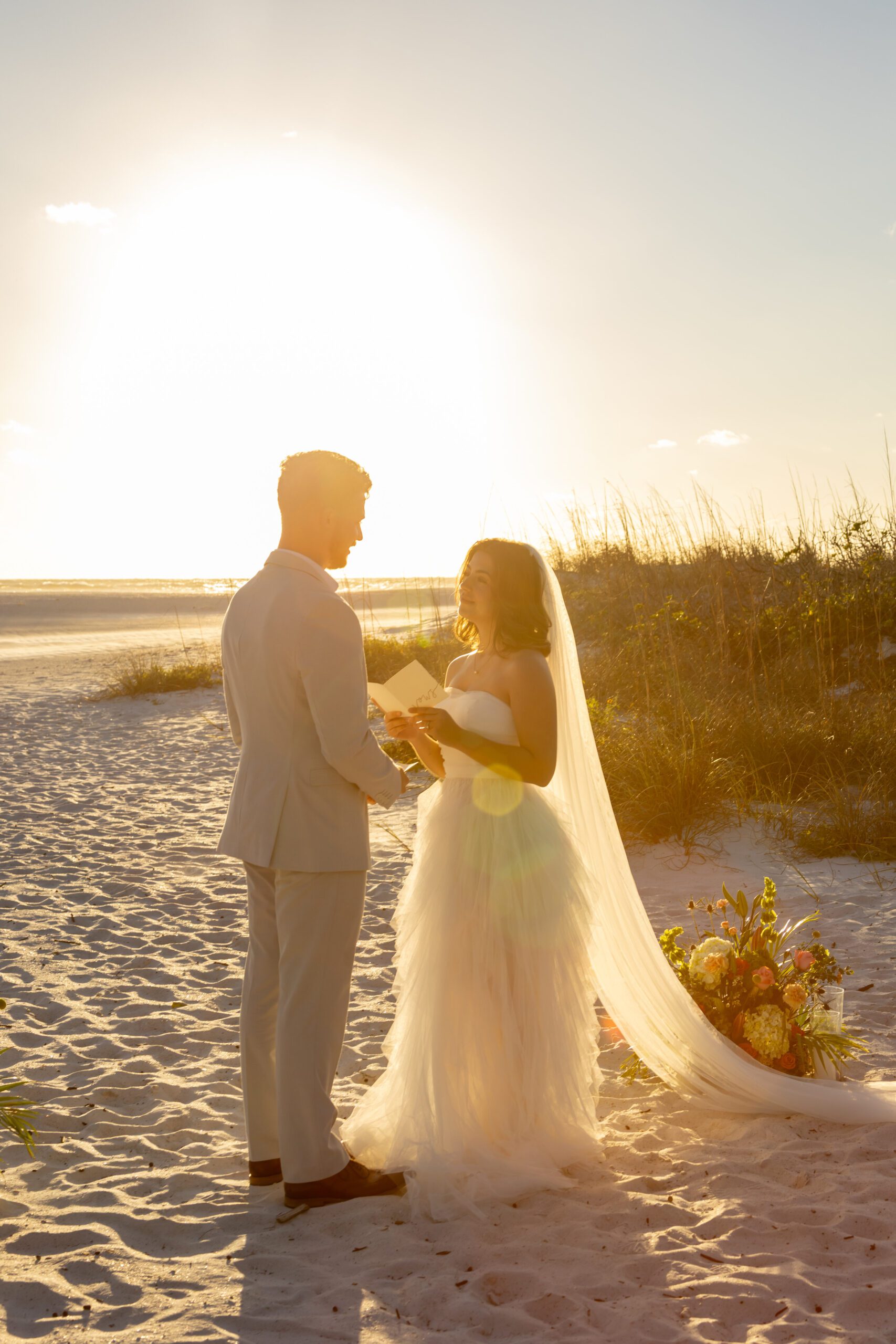 Couple in wedding attire on the beach during sunset in Florida.